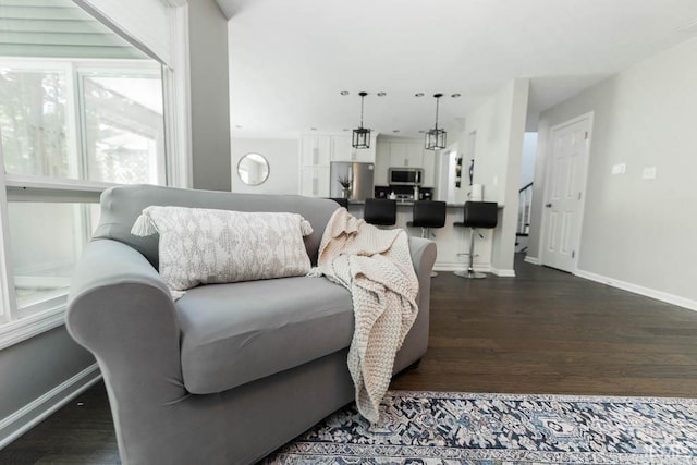 living room with dark wood-type flooring and a chandelier