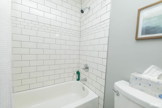 bathroom with tiled shower / bath combo and toilet