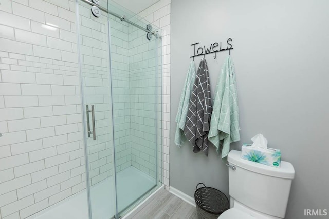 bathroom featuring hardwood / wood-style flooring, toilet, and walk in shower