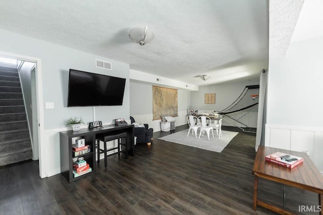 living room featuring dark hardwood / wood-style flooring and a textured ceiling