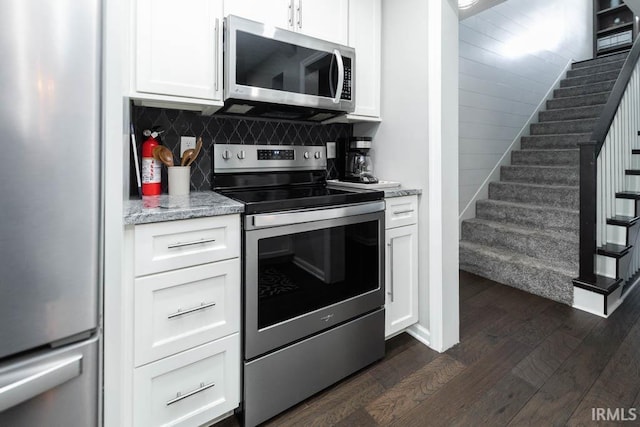 kitchen featuring dark hardwood / wood-style flooring, white cabinetry, stainless steel appliances, and tasteful backsplash