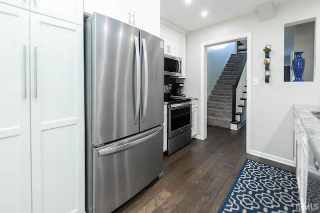 kitchen featuring white cabinets, appliances with stainless steel finishes, dark hardwood / wood-style flooring, and light stone countertops