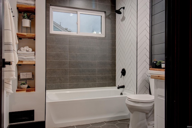 bathroom with toilet, tile patterned floors, and tiled shower / bath