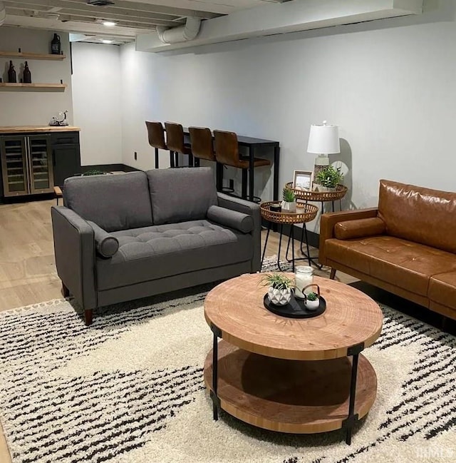 living room featuring hardwood / wood-style floors, wine cooler, and bar area