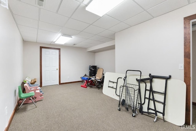 interior space with a paneled ceiling and carpet floors