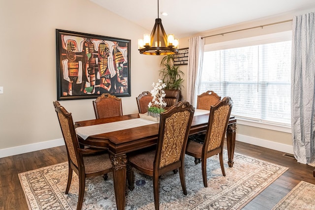 dining room featuring dark hardwood / wood-style floors, vaulted ceiling, and a notable chandelier