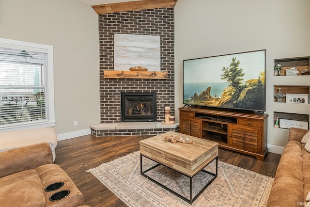 living room with dark hardwood / wood-style floors, a brick fireplace, and lofted ceiling