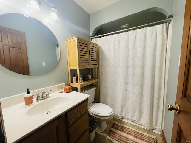 bathroom featuring vanity, a textured ceiling, and toilet