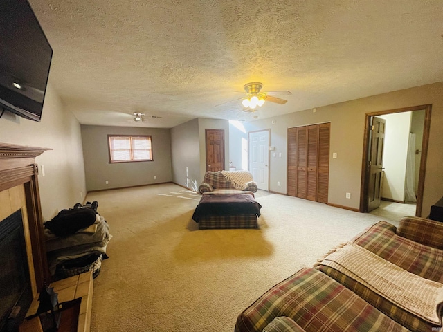 interior space with a textured ceiling, ceiling fan, and a fireplace