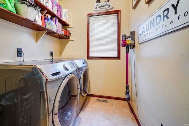 laundry room featuring light tile patterned floors and separate washer and dryer