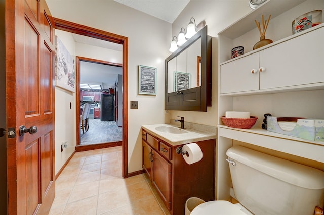 bathroom with tile patterned flooring, vanity, and toilet