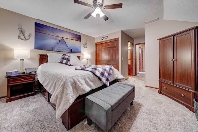 bedroom featuring light carpet, a textured ceiling, vaulted ceiling, ceiling fan, and a closet