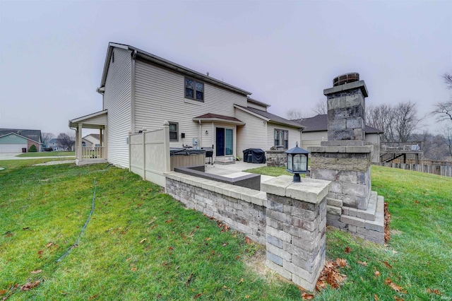 rear view of property featuring a lawn