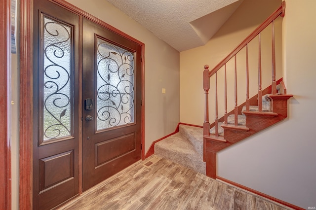 foyer featuring hardwood / wood-style floors, a textured ceiling, and french doors