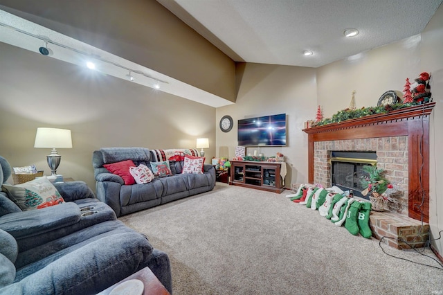 carpeted living room featuring a textured ceiling, track lighting, and a brick fireplace