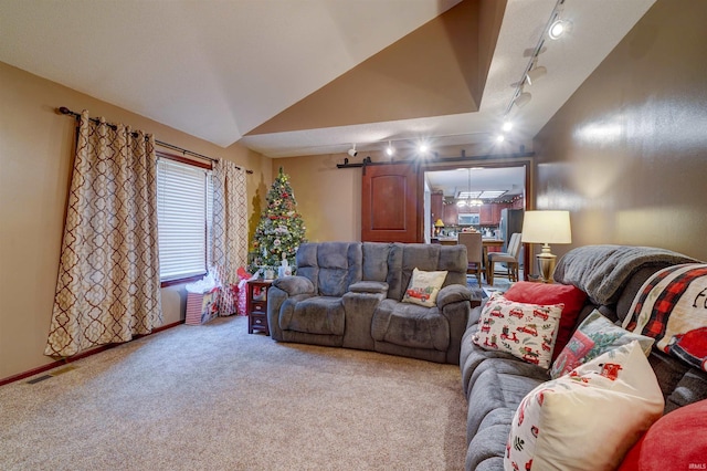 carpeted living room featuring a barn door, track lighting, and vaulted ceiling