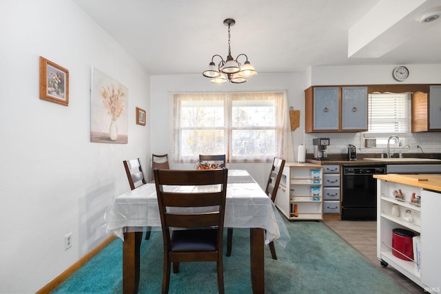 carpeted dining room featuring sink and an inviting chandelier