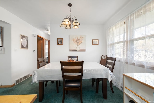 carpeted dining space with an inviting chandelier