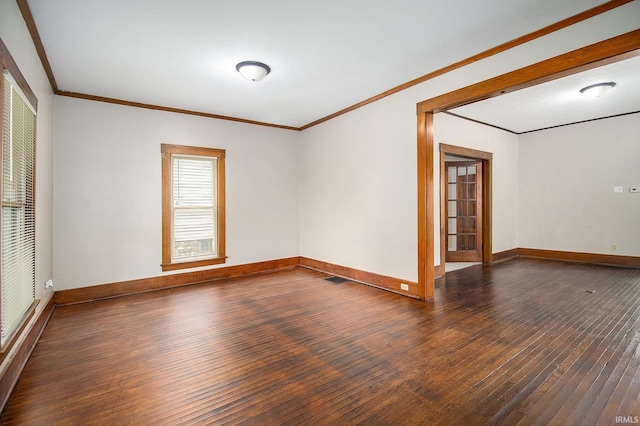 spare room featuring dark hardwood / wood-style flooring and crown molding