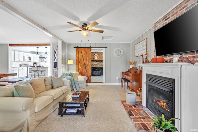 carpeted living room with a fireplace, a textured ceiling, ceiling fan, and wooden walls