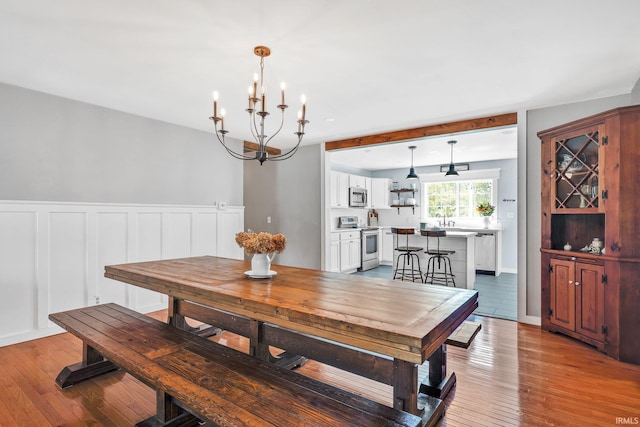 dining room featuring light hardwood / wood-style floors, a notable chandelier, and sink