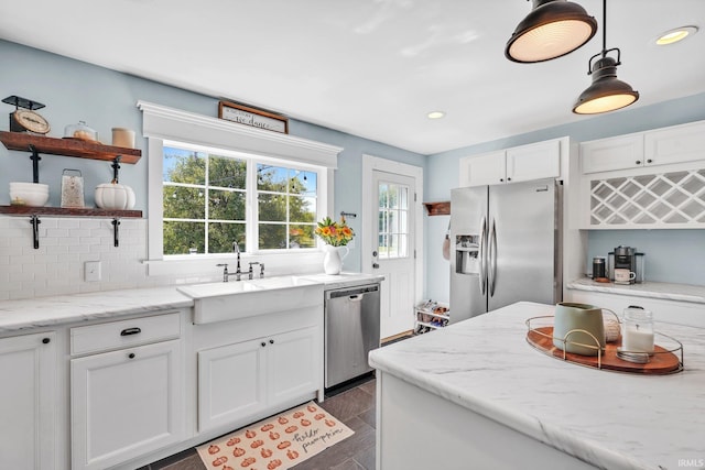 kitchen featuring white cabinets, light stone counters, sink, and appliances with stainless steel finishes