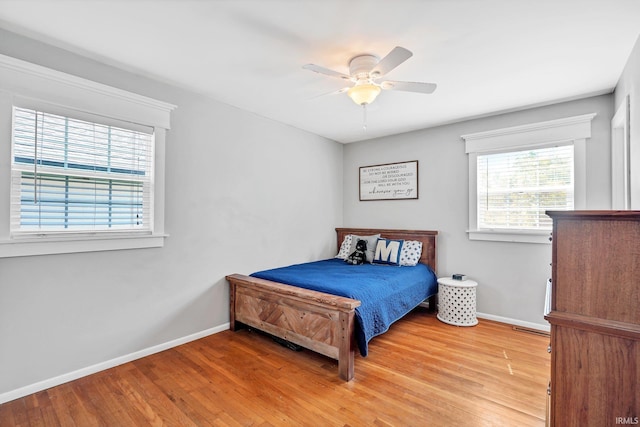 bedroom with multiple windows, hardwood / wood-style floors, and ceiling fan