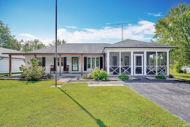 back of property with a lawn and a sunroom