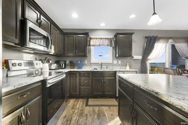 kitchen featuring sink, decorative light fixtures, dark hardwood / wood-style flooring, dark brown cabinets, and stainless steel appliances