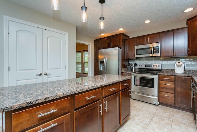 kitchen with appliances with stainless steel finishes, backsplash, dark stone counters, a textured ceiling, and pendant lighting