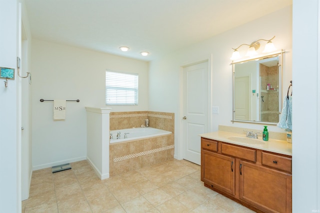 bathroom featuring vanity, a relaxing tiled tub, and tile patterned floors