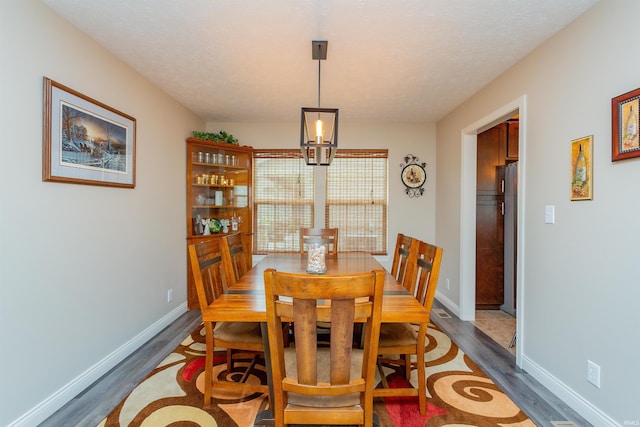 dining area with a textured ceiling and dark hardwood / wood-style floors