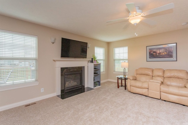 carpeted living room with ceiling fan