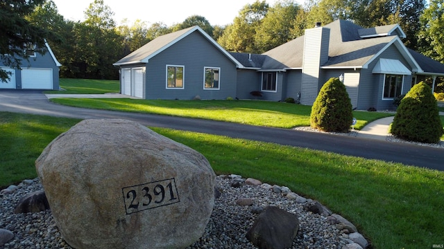 view of front of house featuring a garage and a front lawn