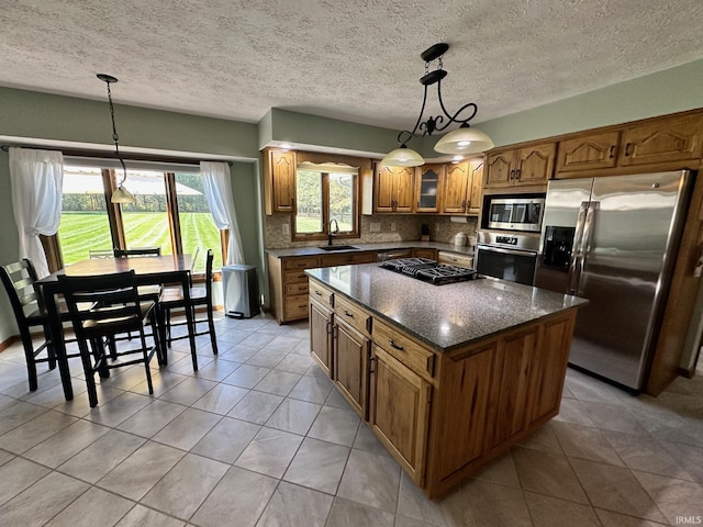 kitchen with tasteful backsplash, a kitchen island, stainless steel appliances, and decorative light fixtures