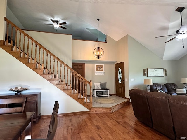 entrance foyer featuring ceiling fan with notable chandelier, hardwood / wood-style flooring, and lofted ceiling