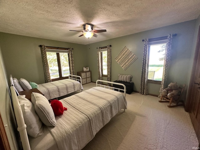 bedroom featuring ceiling fan, light colored carpet, and a textured ceiling