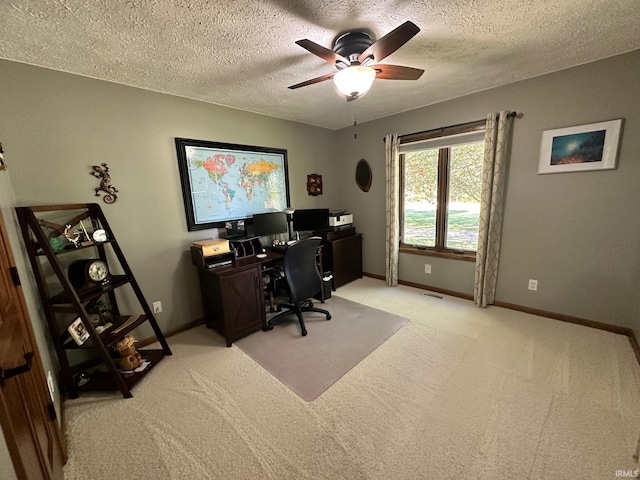 office space featuring light carpet, a textured ceiling, and ceiling fan