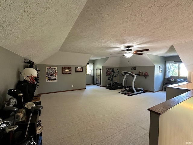 workout area featuring a textured ceiling, ceiling fan, and vaulted ceiling