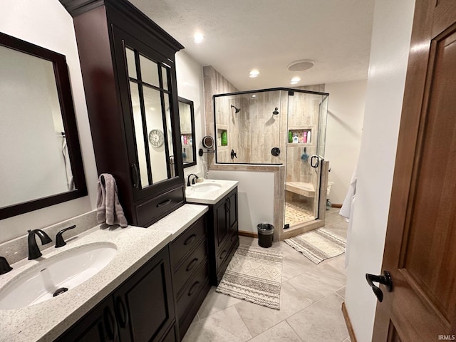 bathroom with tile patterned flooring, vanity, and walk in shower