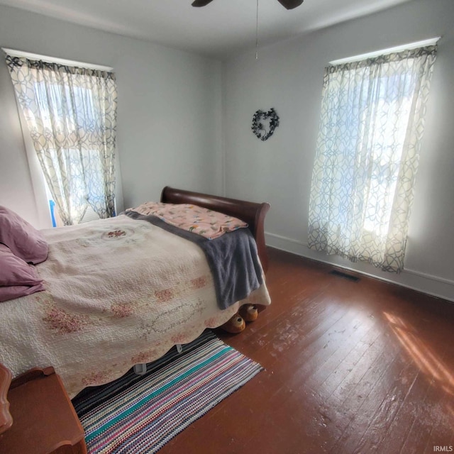 bedroom featuring multiple windows, ceiling fan, and dark hardwood / wood-style flooring