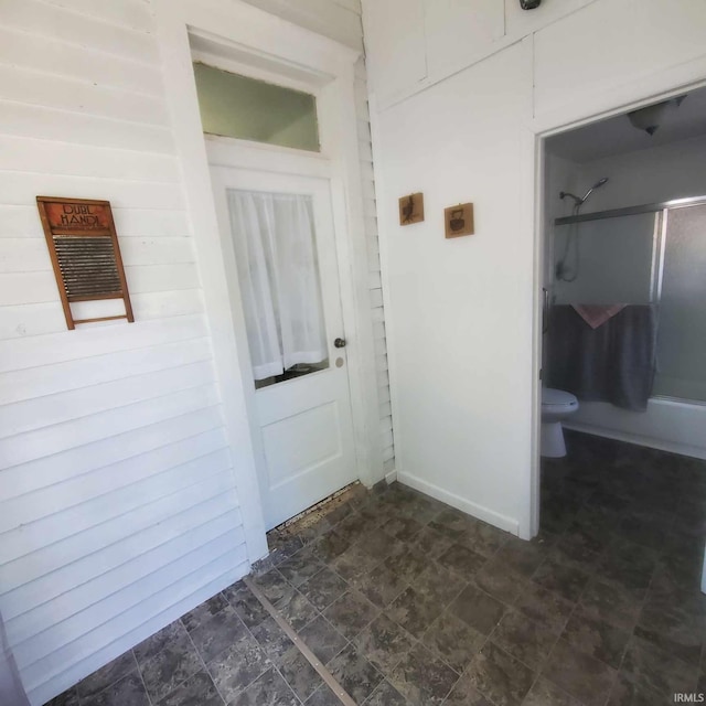 bathroom featuring combined bath / shower with glass door and toilet