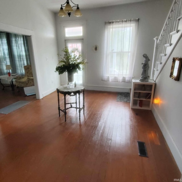 entryway with a notable chandelier and dark wood-type flooring