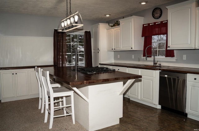 kitchen with white cabinets, dishwasher, sink, and wooden counters