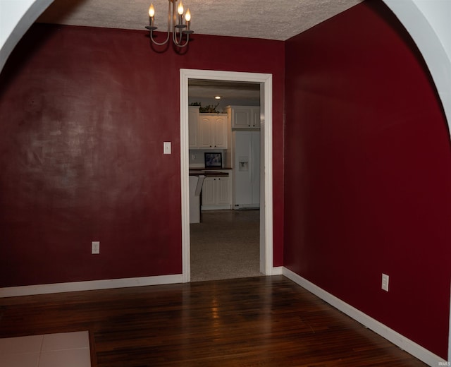 interior space with an inviting chandelier, wood-type flooring, and a textured ceiling