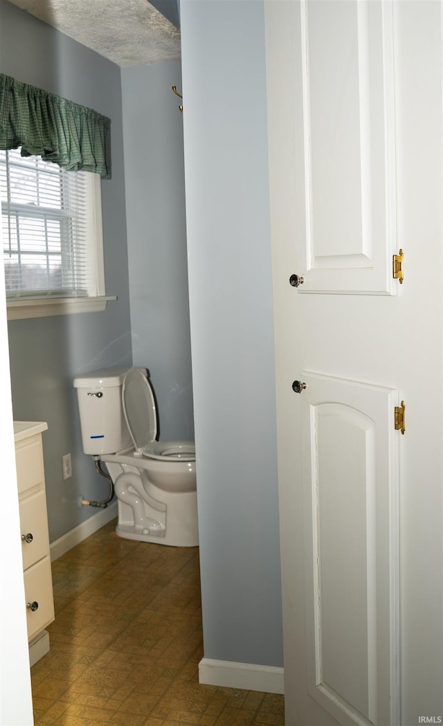 bathroom featuring vanity, toilet, and a textured ceiling