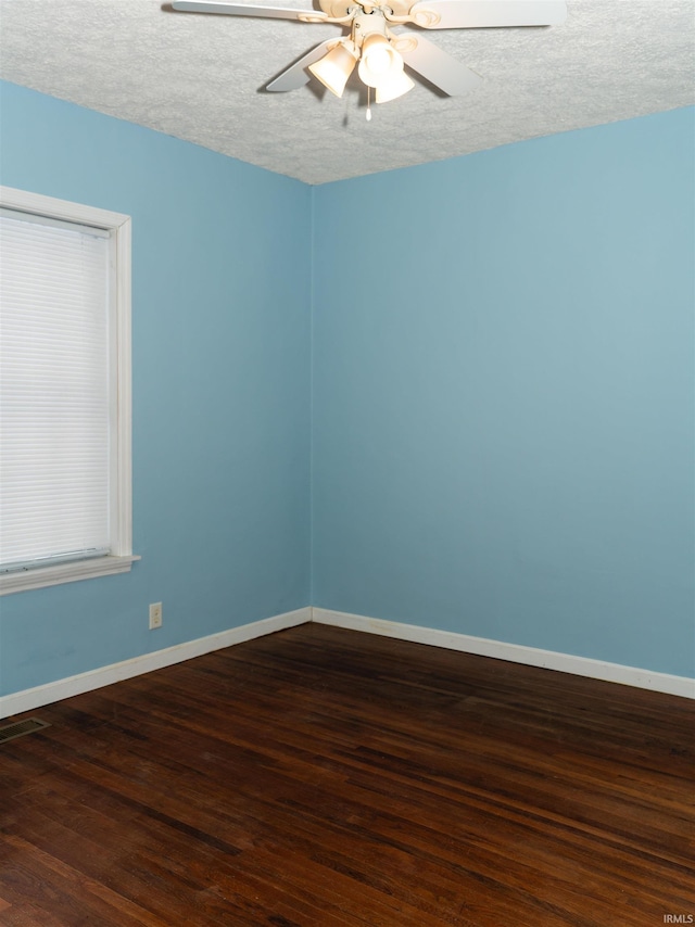 empty room with dark hardwood / wood-style flooring, ceiling fan, and a textured ceiling