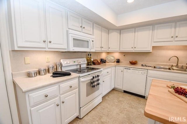 kitchen with white cabinets, white appliances, and sink