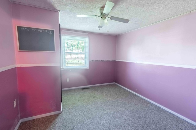 carpeted spare room featuring ceiling fan and a textured ceiling