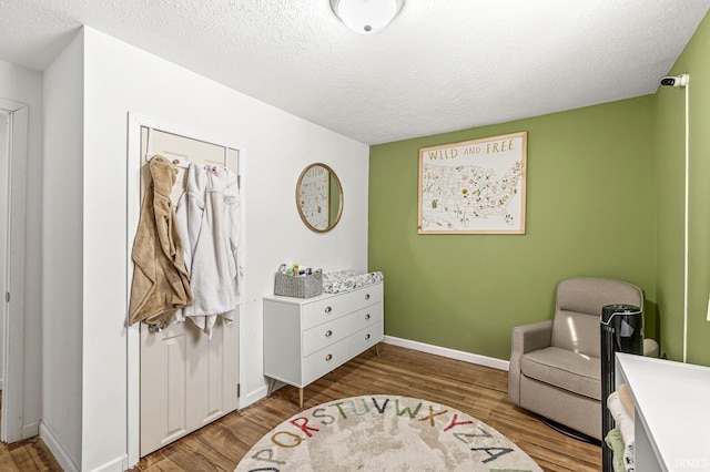 sitting room with light hardwood / wood-style flooring and a textured ceiling